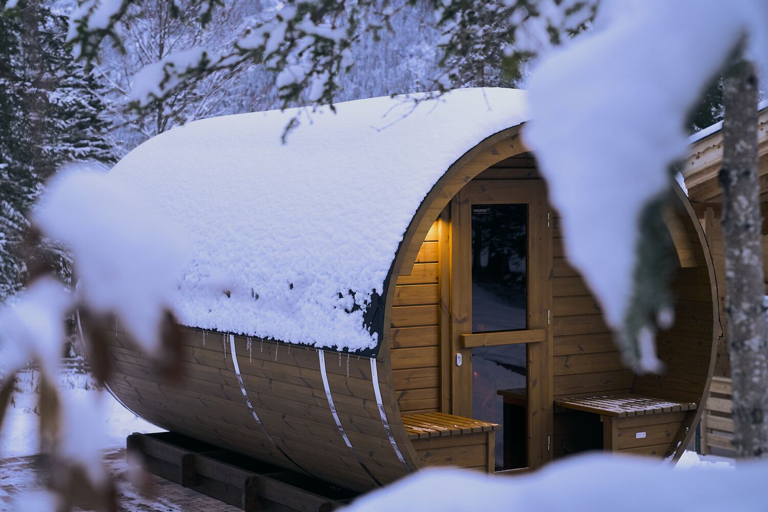 Die Fass-Sauna auf der Terrasse am Waldrand
